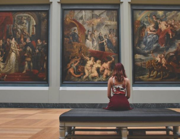 Woman looking at paintings in a museum